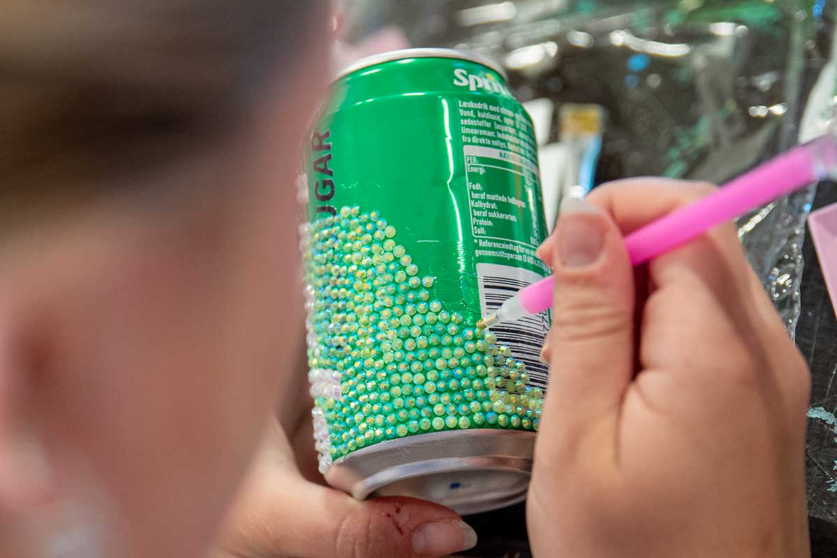 Elev arbejder med mixed media og dekoration af genbrugsmaterialer på Kunstlinjen på Venø Efterskole.