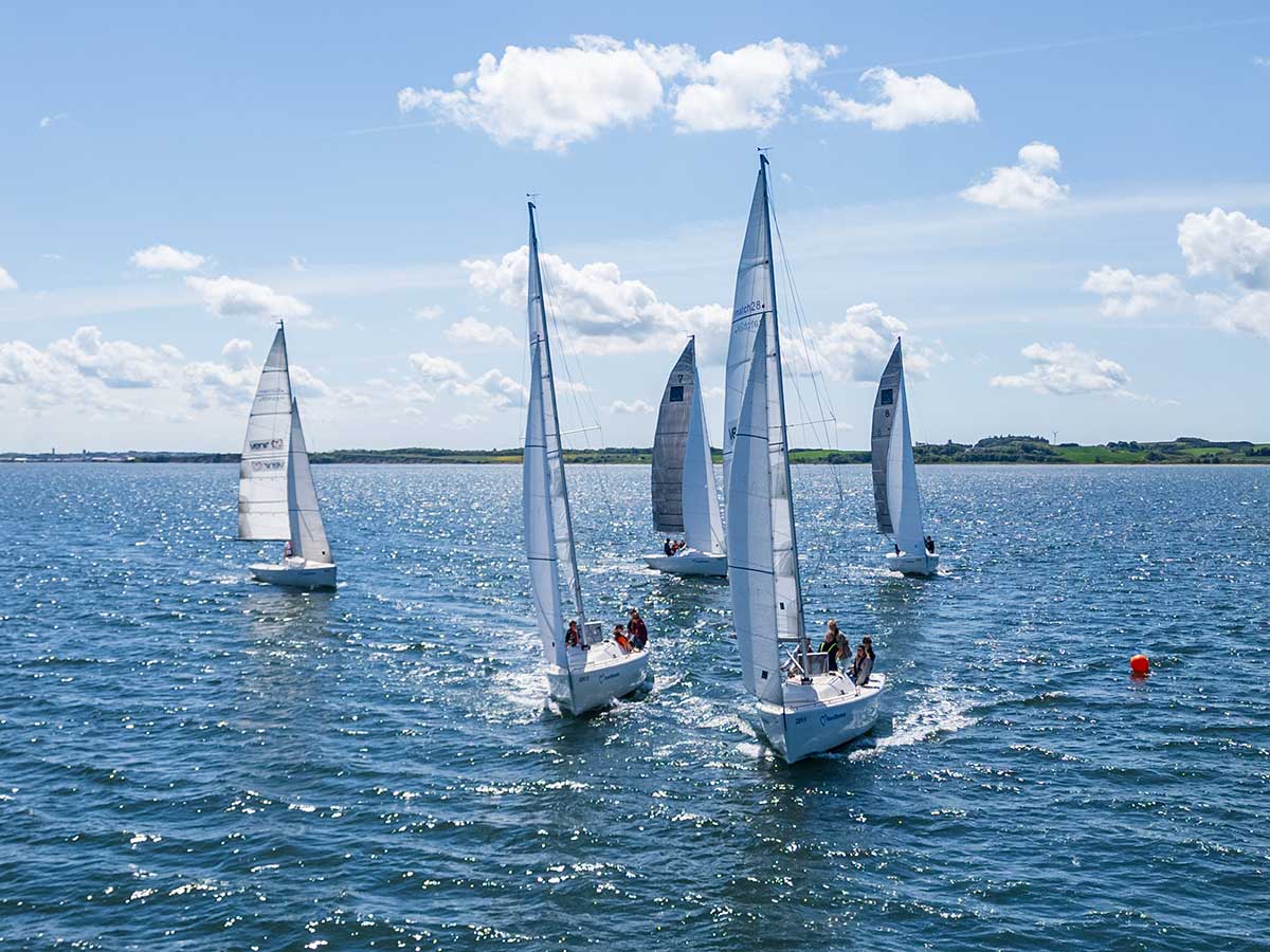 Flere Match 28-sejlbåde deltager i kapsejlads på Limfjorden under sejladsundervisningen på Venø Efterskole.