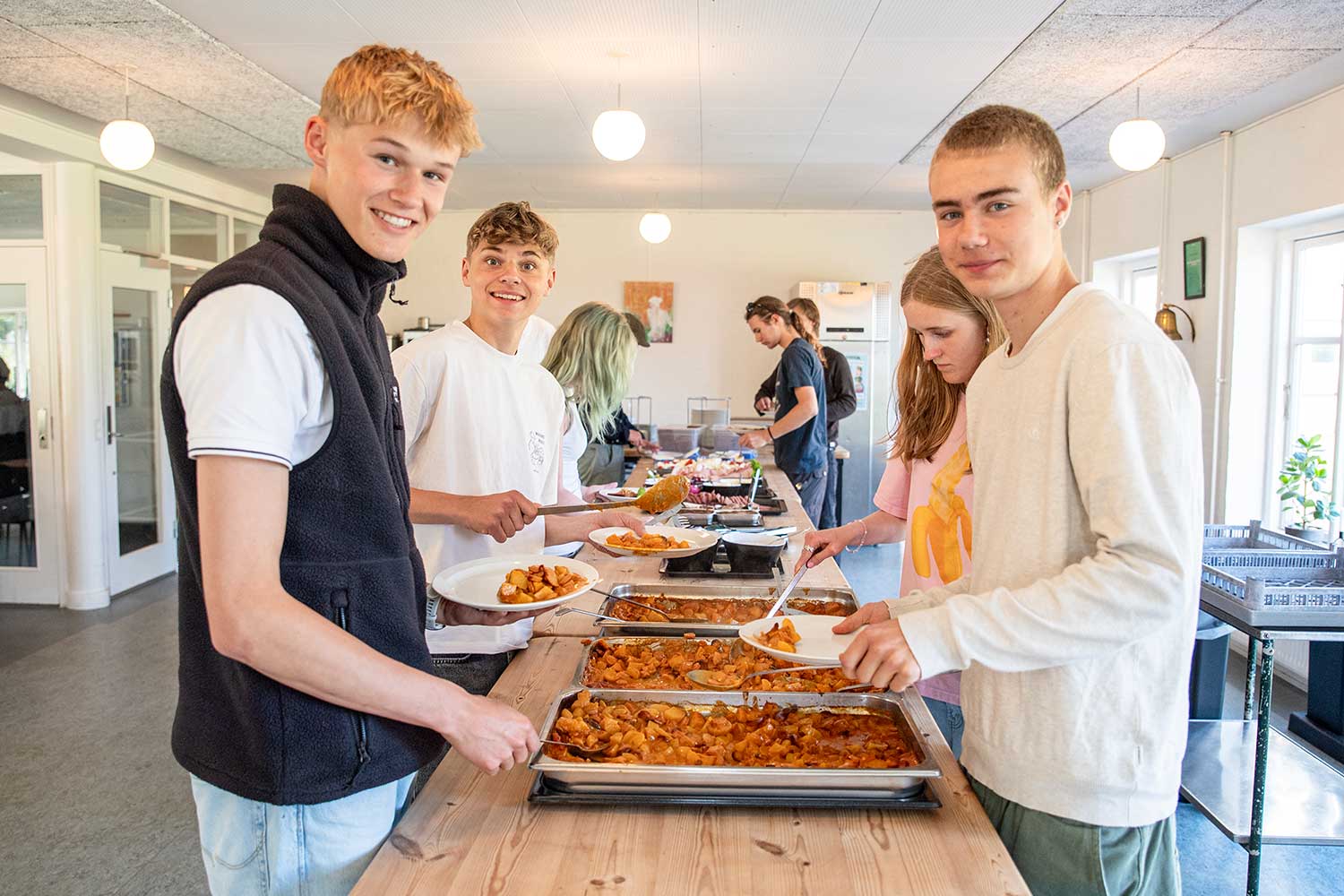 Elever henter aftensmad i spisesalen på Venø Efterskole med hjemmelavet mad fra skolens køkken.